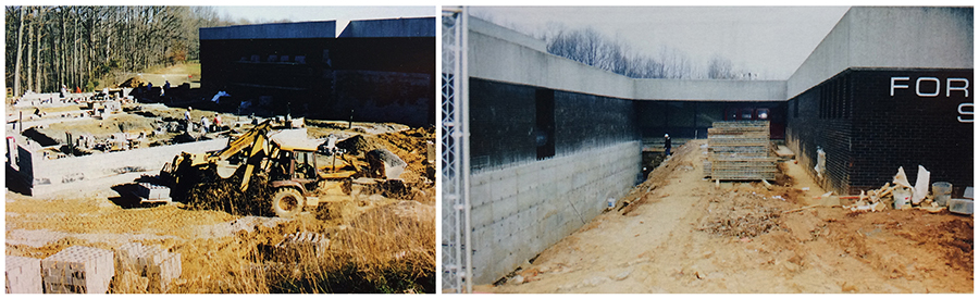 Two color photographs, side-by-side, of the building renovation during the early 2000s. Both show the outside of the building. In the photograph on the left, an area that was once a basketball court has been ripped up and a new wing of the building is being constructed. The cinderblock walls are starting to go up and a backhoe is working the foreground. In the photograph on the right, the sidewalk that led between the original two main wings of the building has been ripped up. The ground has been excavated along the foundation. This section will be enclosed during the renovation and will become part of the new library.   